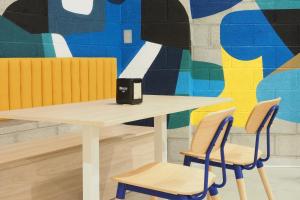 a table and two chairs in front of a mural at Micampus San Mamés Students Residence in Bilbao