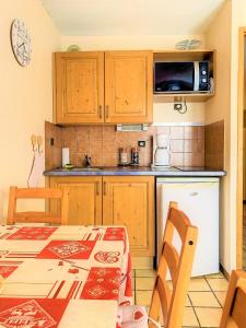 Una pequeña cocina con una mesa y un microondas. en SH104 - Studio 4 pers centre des Carroz, en Les Carroz d'Araches