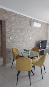 comedor con mesa de cristal y sillas en Nissi Golden Sands Sunny Apartment A1D4, en Ayia Napa