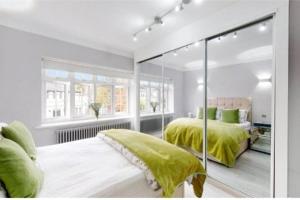 a bedroom with two beds with green comforters at 9 Brentwood Lodge in London