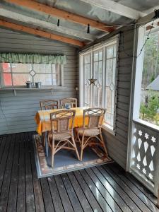 una mesa y sillas en un porche cubierto en Älghuset, en Silverdalen