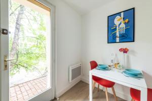 uma sala de jantar com uma mesa branca e cadeiras vermelhas em Terrasse des Loges em Rennes