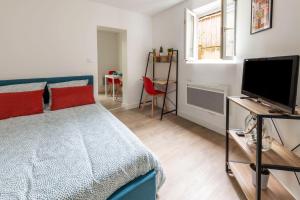 um quarto com uma cama azul e uma televisão em Terrasse des Loges em Rennes
