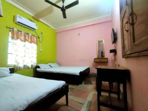 En eller flere senge i et værelse på STAYMAKER Rituranga - 5 Mins Walk from Sonajhuri Haat