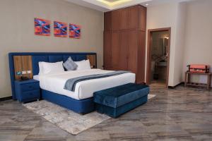 um quarto com uma cama grande com uma moldura azul em South Gate Hotel Apartment em Addis Ababa