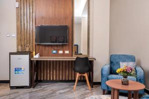 Habitación con TV, silla y mesa. en South Gate Hotel Apartment, en Addis Ababa