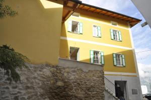 a yellow house with a stone wall at Agriturismo Eredi di Cobelli Aldo in Lavis +15 photos