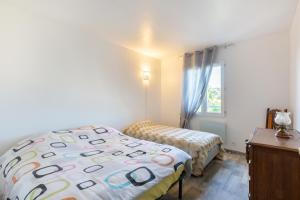 Un dormitorio con dos camas y una ventana. en Le Bel Vedere, en Saint-Aygulf