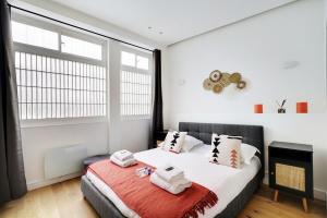 a bedroom with a bed and a large window at CMG - Charmant et cosy appartement 4 Pax - Bastille in Paris