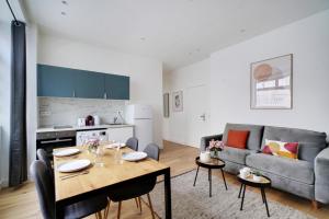 a kitchen and living room with a table and a couch at CMG - Charmant et cosy appartement 4 Pax - Bastille in Paris