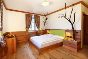 a bedroom with a bed and a tree on the wall at Agriturismo Eredi di Cobelli Aldo in Lavis