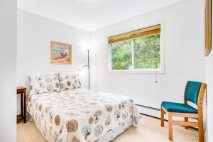 a bedroom with a bed and a chair and a window at Radar Road Retreat Vacation Rental in Oceanside