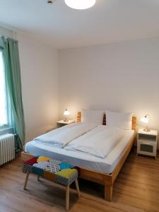 a bedroom with a large white bed with a chair at Gasthof zur Waag in Bad Zurzach