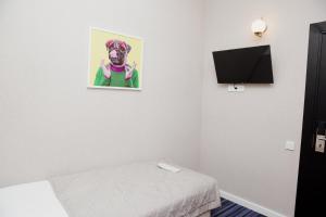 AMINA HOTEL في أستانا: غرفة بسرير وصورة كلب