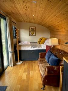 a living room with a couch and a bed at Robin's Nest (Top Cabin) in Foolow