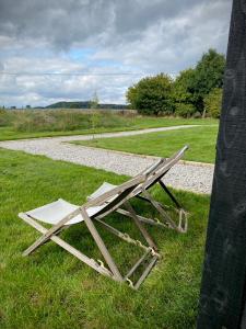 a wooden bench sitting in the grass near a field at Robin's Nest (Top Cabin) in Foolow