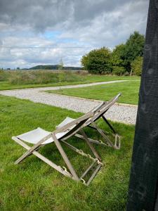 a wooden bench sitting in the grass near a field at Robin's Nest (Top Cabin) in Foolow +2 photos
