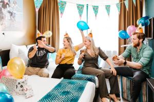 a group of people sitting in a room with balloons at The Hague Teleport Hotel - Free Parking in The Hague