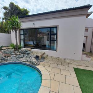 a house with a swimming pool in a yard at Balmoral Cottage, West Beach in Cape Town