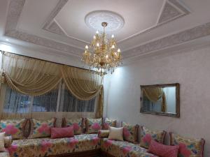 sala de estar con sofá y lámpara de araña en Majorelle appartement, en Fez