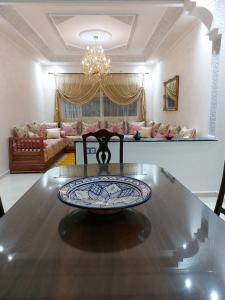 una sala de estar con una mesa con un plato. en Majorelle appartement en Fez
