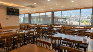 a restaurant with wooden tables and chairs and windows at LOTUSPARK HOTEL in Bursa