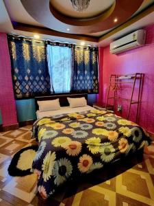 a bedroom with a bed with a floral comforter at LEISHA Duplex in Imphal