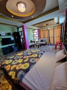 a bedroom with a large bed with a floral blanket at LEISHA Duplex in Imphal