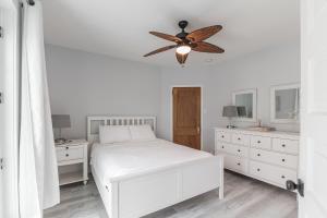 a bedroom with a white bed and a ceiling fan at Beach Block-Ocean Views from Balconies-Parking Unit 2 in Ventnor City