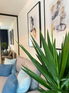 un salon avec un canapé et une plante en pot dans l'établissement Ultra Apartments Kamienica Nova II, à Szczecin