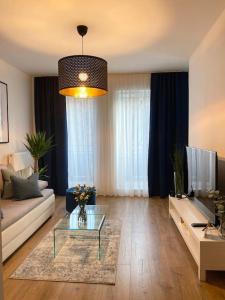 - un salon avec un canapé et une table dans l'établissement Ultra Apartments Kamienica Nova II, à Szczecin