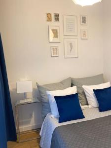 - une chambre avec un lit doté d'oreillers bleus et blancs dans l'établissement Ultra Apartments Kamienica Nova II, à Szczecin
