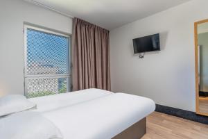 a hotel room with a bed and a window at B&B HOTEL Marseille Euromed in Marseille