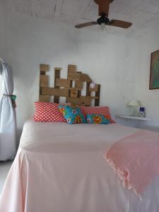 a bedroom with a white bed with red pillows at Mediterrâneo Flat Praia da Gamboa- Cabanas da Candoca in Garopaba