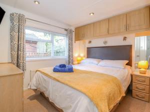a bedroom with a large bed and a window at Fell Foot Lodge in Windermere