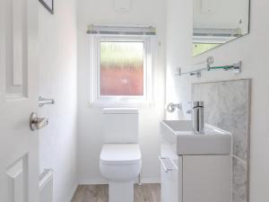 a white bathroom with a toilet and a sink at Fell Foot Lodge in Windermere +16 photos