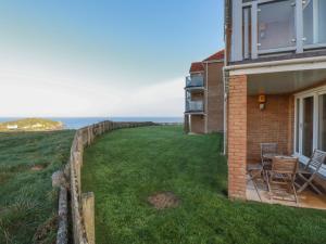 a house with a large yard next to the ocean at 9 Headland Point in Newquay