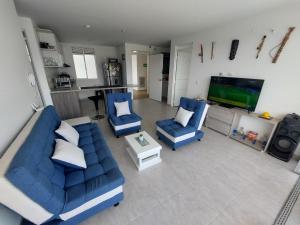 sala de estar con 2 sofás azules y TV en Apartamento Aqualina Orange Quinto Piso Vista a Montañas, en Girardot