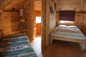 1 dormitorio con 1 cama en una cabaña de madera en Le Bois Davy, en Le Thoureil