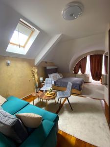 ein Schlafzimmer mit einem Bett, einem Sofa und einem Tisch in der Unterkunft Freya SPA Apartments in Niš