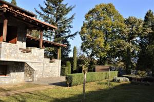 a stone house with a garden and trees at Happy trails Guesthouse Vitina in Vytina