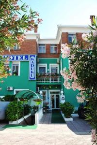 - un bâtiment vert et blanc avec un balcon dans l'établissement Hotel Kaduku, à Shkodër