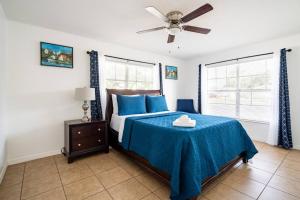 um quarto com uma cama com lençóis azuis e uma ventoinha de tecto em Perfectly Situated 2-BR Residential Home in Largo- Close to Beach and everything!! em Largo