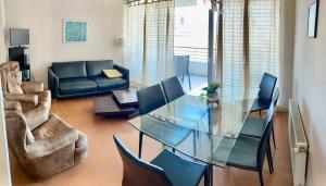 sala de estar con mesa de cristal y sillas en Departamento Alto Libertad Meseta Coraceros, en Viña del Mar