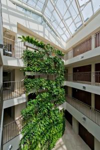 un bâtiment avec un mur vert de plantes dans l'établissement Amberton Green Apartments Palanga, à Palanga
