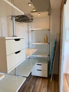 a walk in closet with white drawers and shelves at Apartment Rebe in Schweinfurt