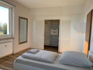 a white bedroom with a bed and a window at Apartment Rebe in Schweinfurt