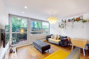 a living room with a couch and a table at Charming 2-bedroom maisonette with private garden in London