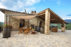 un patio avec une table et des chaises sous un pavillon dans l'établissement Villa Sempreverde - Homelike Villas, à Greve in Chianti