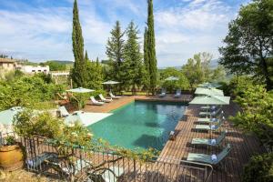 - une piscine avec des chaises longues et des parasols dans l'établissement Villa Sempreverde - Homelike Villas, à Greve in Chianti